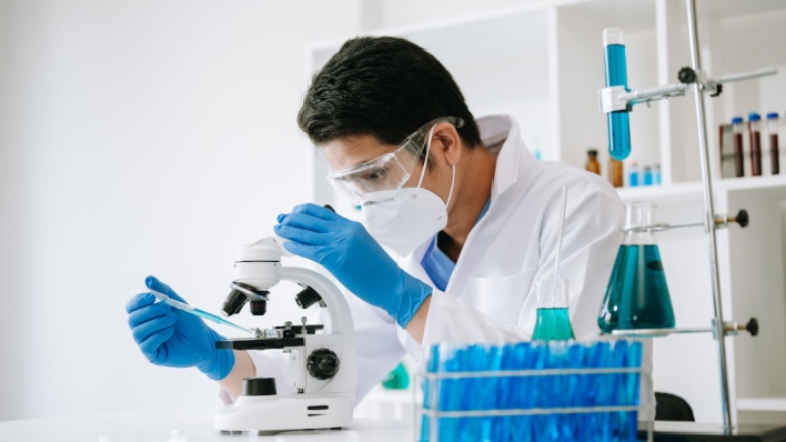Científico mirando a través del microscopio