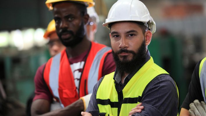 Un equipo de ingenieros con cascos mirando directamente a la cámara