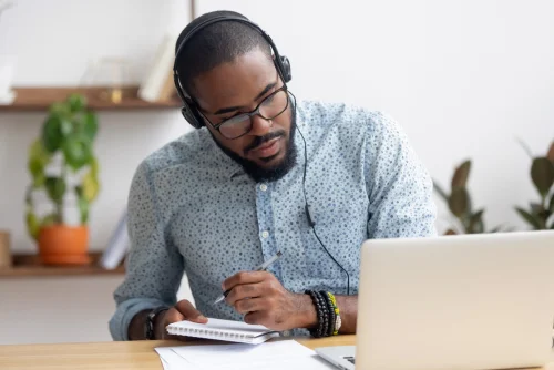 man taking notes online class